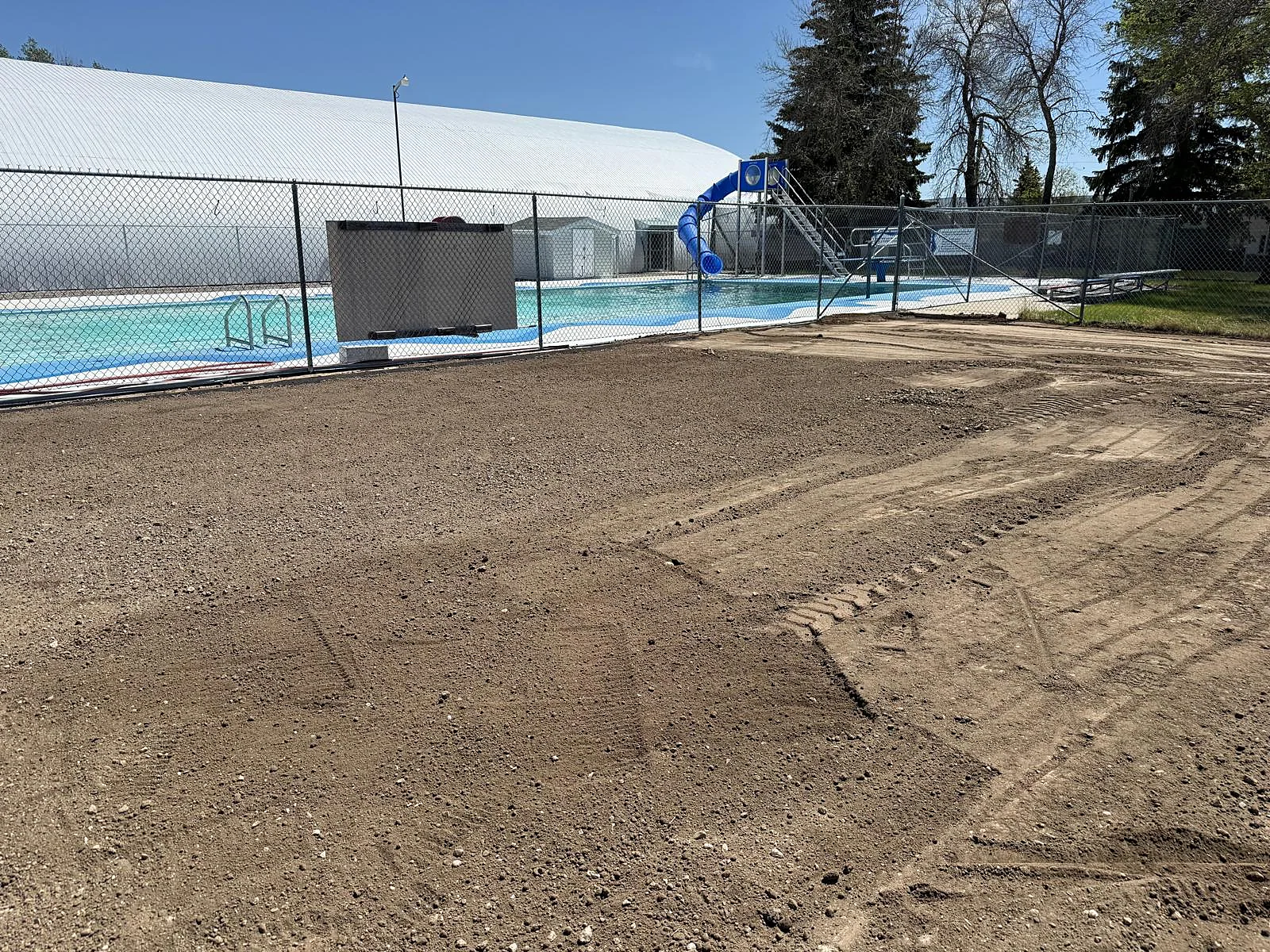 Wider view of soil preparation and grading by the pool