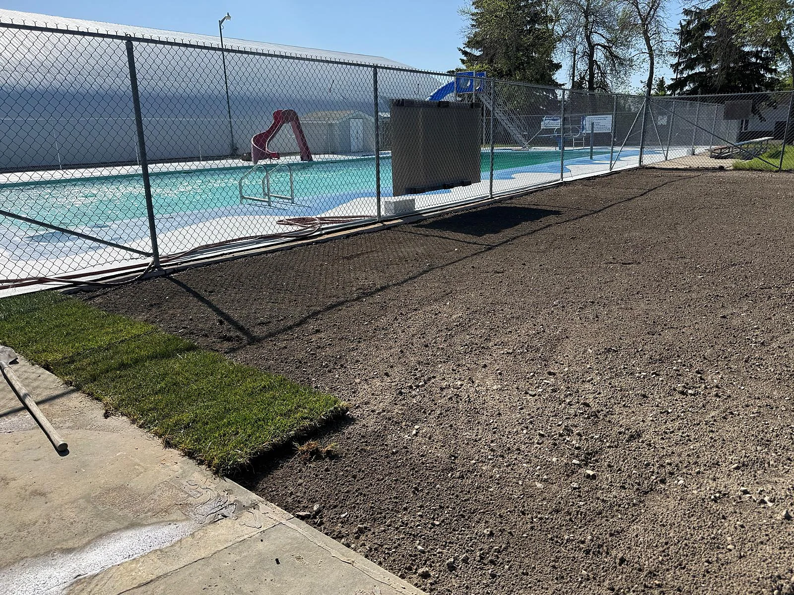Fresh sod laid alongside prepared ground at the pool