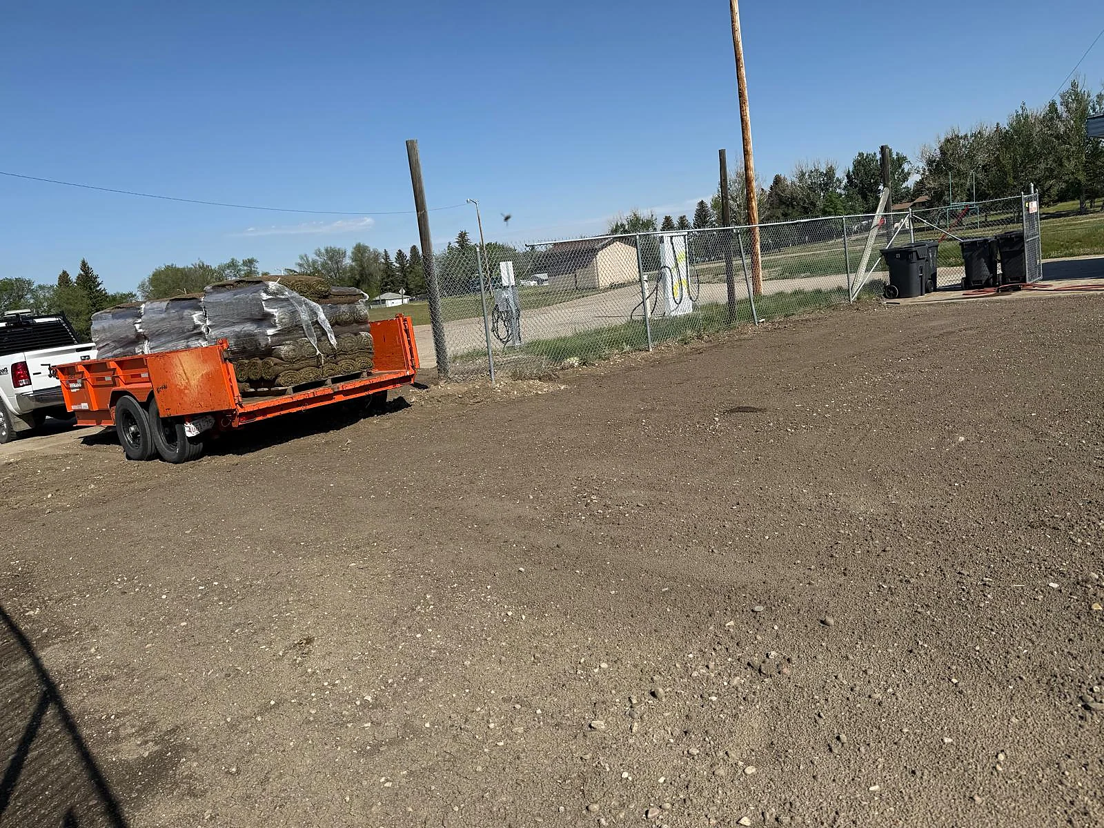 Delivery trailer carrying rolls of sod to the project site